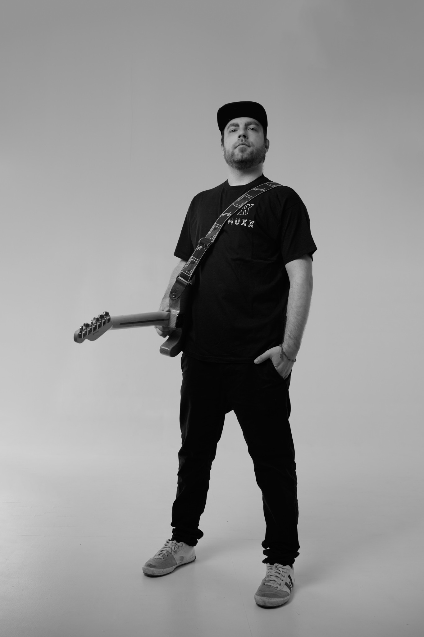 Black and white artist portrait of HUXX with guitar